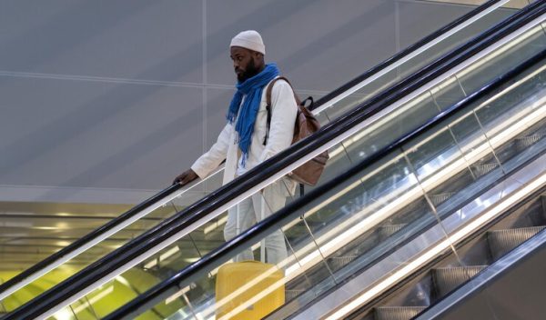 african-american-passenger-man-with-suitcase-stands-escalator-holds-handrail-airport-terminal_165285-7358