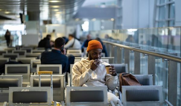 young-african-man-drinking-coffee-eating-sandwich-while-waiting-flying-airport-terminal_1048944-16561257